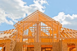 New residential construction home framing against a blue sky